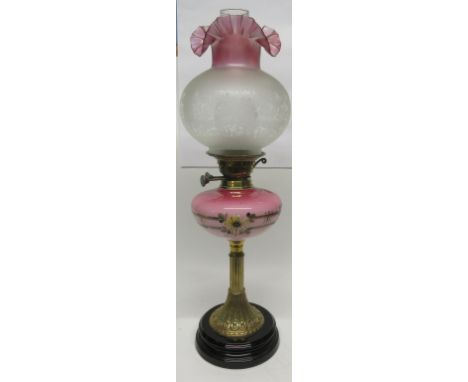 Oil lamp with decorated brass column and pink glass reservoir decorated with flowers and globular shade with floral decoratio