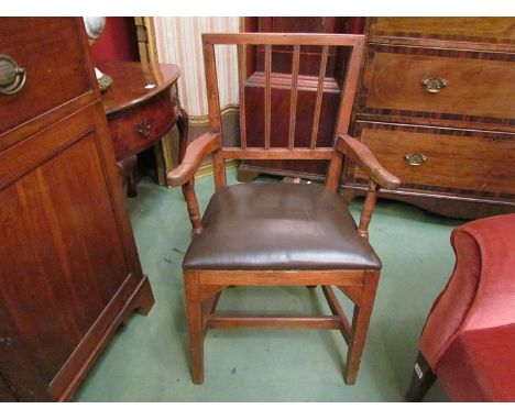 An Arts & Crafts oak stick-back elbow chair, leather upholstery, stretcher base 