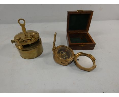 A BOXED COMPASS AND A BRASS NAVIGATION TOOL