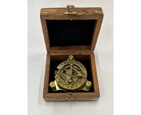 A BRASS SUNDIAL COMPASS IN A WOODEN PRESENTATION BOX