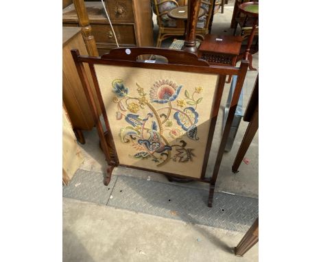 A MAHOGANY ARTS AND CRAFTS STYLE FIRESCREEN WITH INSET FLORAL WOOLWORK PANEL