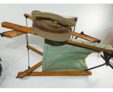 A 20TH CENTURY ROYAL ARTILLERY OFFICERS CAP AND FOLDING STOOL DATED 1945