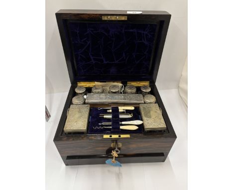 A VICTORIAN COROMANDEL TRAVELING VANITY CASE IN A ROSEWOOD BOX WITH KEY CONTAINING SILVER PLATE TOPPED BOTTLES, SIX MANICURE 