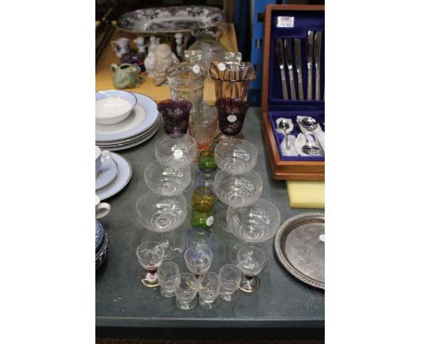 A QUANTITY OF COLOURED AND CLEAR GLASS TO INCLUDE VASES, CANDLESTICKS, A PAIR OF ETCHED PURPLE WINE GLASSES WITH TWISTED STEM