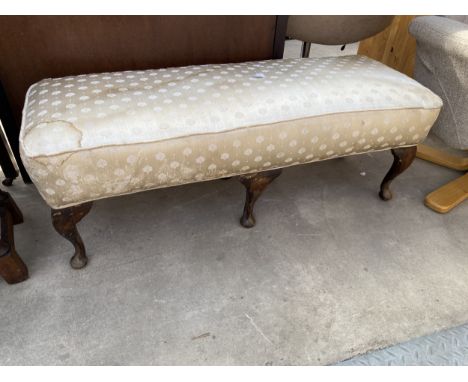AN UPHOLSTERED STOOL ON SIX CABRIOLE LEGS