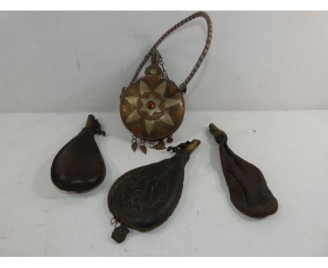 AN ARAB DECORATIVE METAL POWDER FLASK AND THREE LEATHER AND BRASS SHOT FLASKS (4)