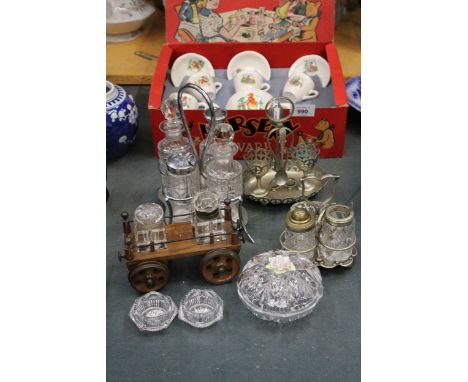 A QUANTITY OF GLASS WITH SILVER PLATED TOPS CRUET SETS ON STANDS TO INCLUDE ONE ON A WOODEN CART, AN EGG CUP SET A GLASS TRIN