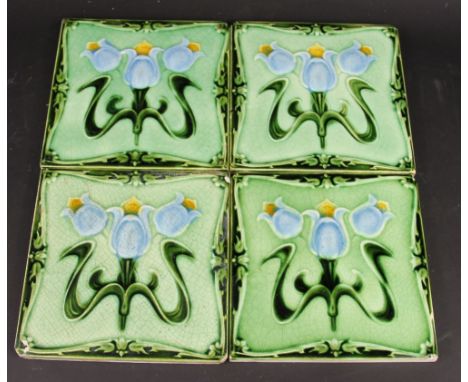 Four Art Nouveau ceramic tiles, decorated with stylised flowers, 15cm (4)