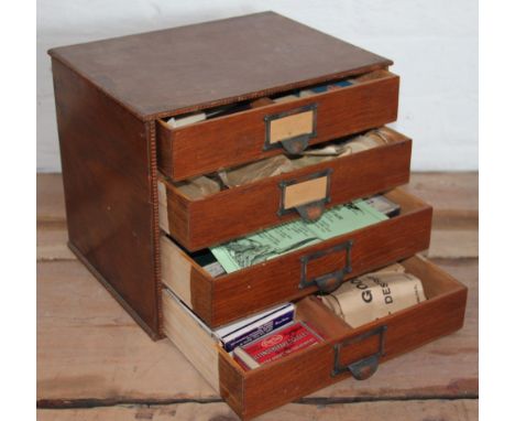 An oak bank of four drawers enclosing various old vetinary tools and equipment, 32cm tall