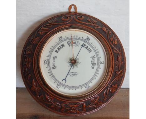 A Stanley of London carved oak aneroid barometer, 26cm dameter