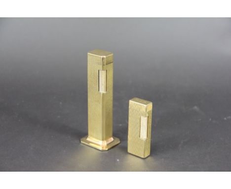 A Dunhill 'Tallboy' table lighter, 11cm high and a further Dunhill lighter with zig zag decoration throughout 'US. RE24163', 