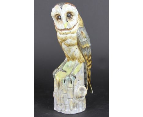 A German porcelain model of a barn owl, perched on a tree stump, impressed number 2450, 31cm