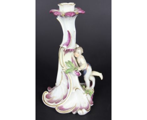 An 18th century Vienna porcelain figural candlestick, Rococo design modelled with a putto (restored), with a Vienna cup paint