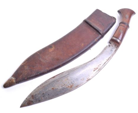 WW2 Gurkha Kukri Knife, housed in its original brown leather covered scabbard. Wooden handle with two brass rivets. Curved bl