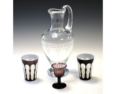 Early 19th Century amethyst glass egg cup, together with two overlaid window-cut beakers and a Victorian amphora shaped glass