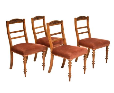 Manner of James Shoolbred, set of four late 19th century upholstered walnut dining chairs, the backs with carved sunflower mo