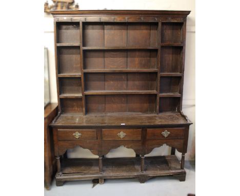 Small 18th Century oak dresser, the boarded shelf back above three drawers, a shaped frieze and an open pot shelf, 155cm x 41
