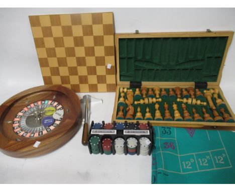 Folding chess board with chess pieces, a roulette wheel, gaming counters and sundries
