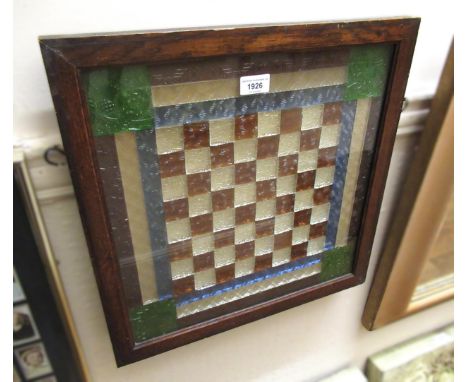 Leaded and coloured glass window panel, in the form of a chess board, 48cm square, framed and glazed, together with a similar