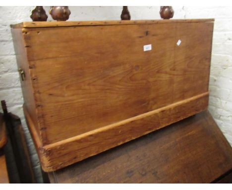 Stripped polished pine trunk, the hinged cover enclosing a candle box, raised on casters, 90cm wide x 46cm deep x 54cm highMi