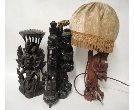 Two Chinese carved hardwood lamp bases, together with an African carved lamp base, and an Indian hardwood carving