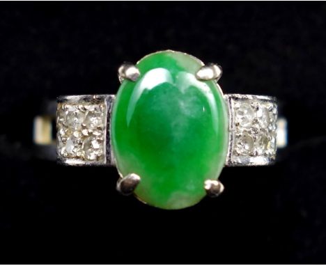 A JADE AND DIAMOND DRESS RING, CENTRALLY SET WITH AN OVAL CABOCHON CUT JADE, MEASURING APPROXIMATELY 9.7 X 7.1MM, WITH SIX SI