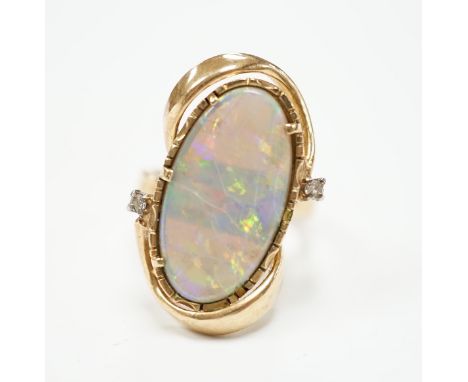 A yellow metal and oval cut black opal set dress ring, with two stone diamond chip set border, size M, gross weight 8.2 grams