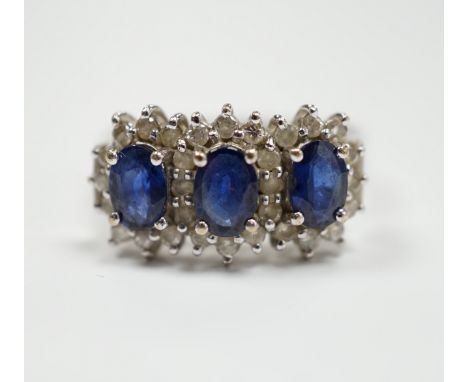 An 18k white metal, sapphire and diamond set triple cluster ring, size Q. gross weight 5.8 grams.