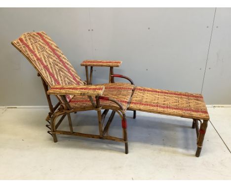 A vintage French caned bamboo reclining garden chair with footrest Binding loose to right front leg. Evidence of old worm but