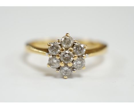 A modern 18ct gold and seven stone diamond cluster set flower head ring, size N, gross weight  3.6 grams.