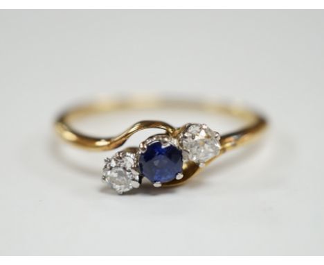 An 18ct, single stone sapphire and two stone diamond set crossover ring, size O, gross weight 2.2 grams.