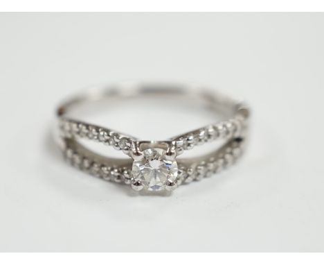 A modern 18ct white gold and single stone diamond set ring, with diamond chip set split shoulders, size O, gross weight 4.2 g