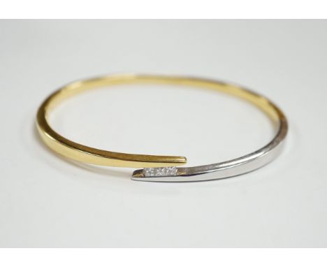 A modern two colour 18k and three stone princess cut diamond set hinged bangle, interior 60mm, gross weight 23.4 grams.