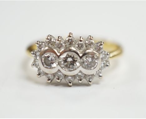 A modern 18ct gold and collet set three stone diamond ring, with diamond chip set border, size J/K, gross weight 4.6 grams.