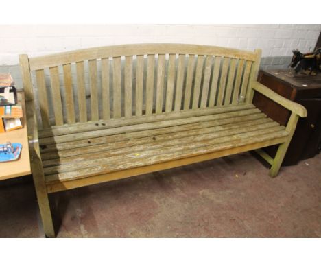 A LARGE WOODEN GARDEN BENCH