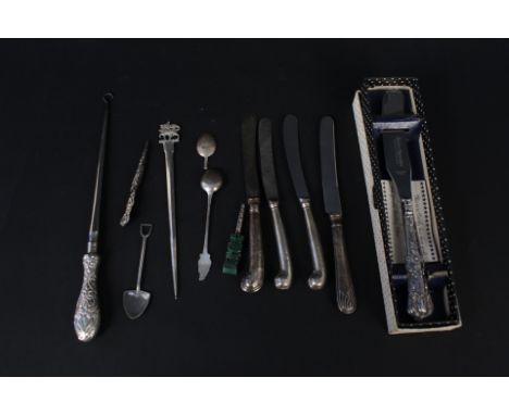 A mixed lot of silver handled butter knives, cake knife, button hooks, three white metal spoons and a silver meat skewer with