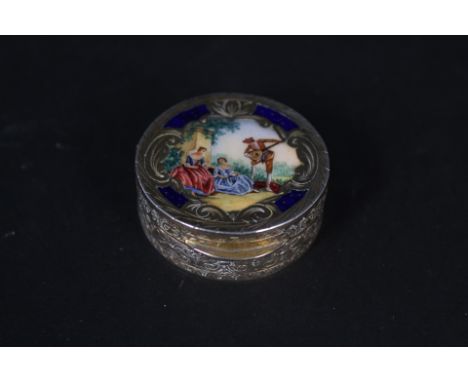 A continental 800 grade silver pill pot with extensive engraved decoration all over and enamelled scene to lid of a musician 