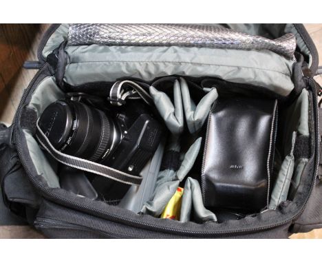 A cased Canon camera with zoom lens and accessories