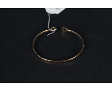 A 9ct gold bangle with double heart decoration