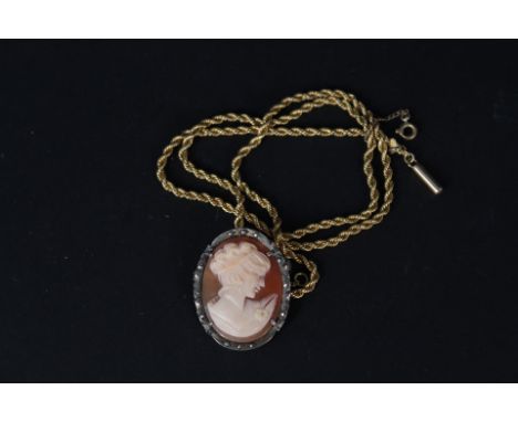 A 15ct gold rope chain necklace and a silver framed cameo pendant
