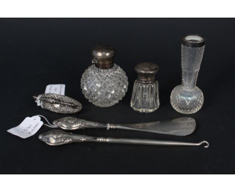 A silver topped cut glass scene bottle, a small similar, a silver rimmed glass bud vase, three items of silver handled pieces