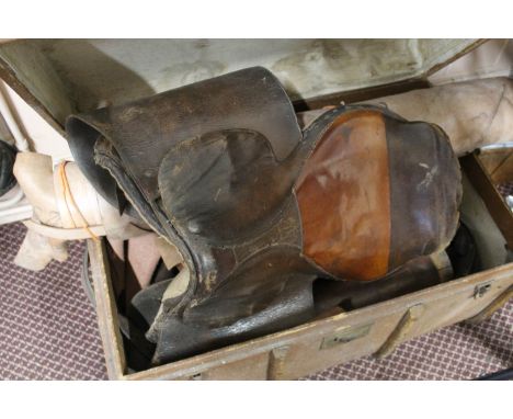 A cabin trunk containing a saddle and horse riding equipment plus a leather roll