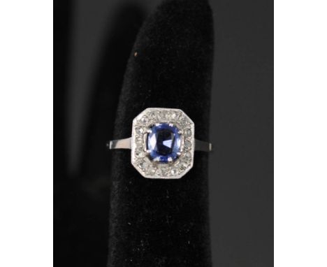 A sapphire and diamond Art Deco style platinum set cluster ring, the central sapphire surrounded by square setting set with m