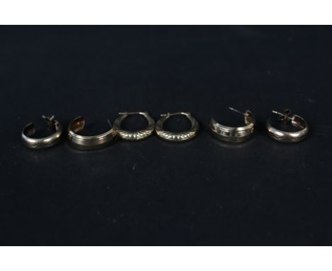 A pair of 9ct gold hoop earrings and two other pairs of yellow metal hoop earrings