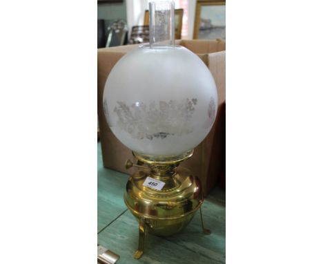 A brass oil lamp with etched glass shade