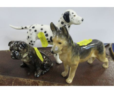 Three Royal Worcester models of dogs, to include a standing Dalmatian, a brindle seated Bulldog and an Alsatian, all modelled
