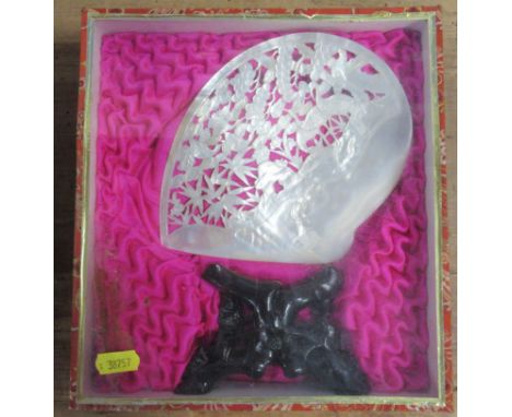 A carved mother of pearl shell and stand, in a glazed case, case 9.5ins x 9insCondition Report:  The shell is stained, possib