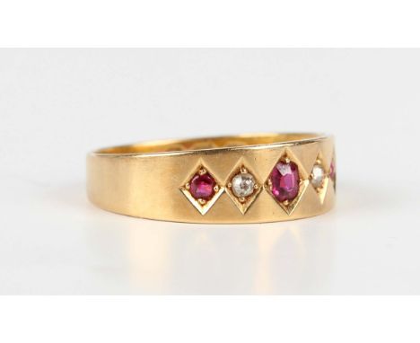 A late Victorian 18ct gold, ruby and diamond ring, mounted with three cushion cut rubies alternating with two cushion cut dia