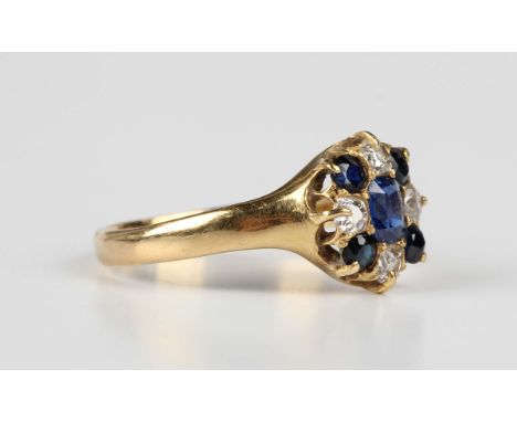 A Victorian 18ct gold, sapphire and diamond cluster ring, claw set with the principal cushion cut sapphire within a surround 