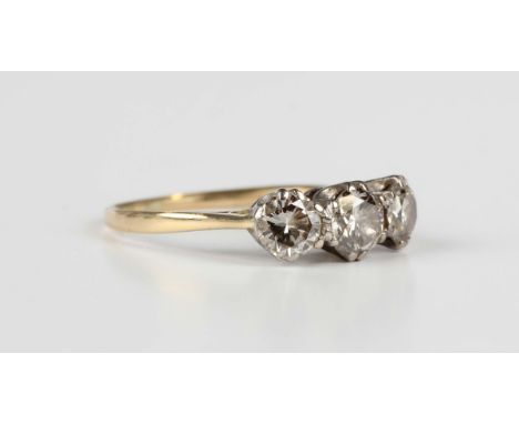 A gold and diamond three stone ring, mounted with a row of circular cut diamonds, unmarked, weight 2.3g, total diamond weight